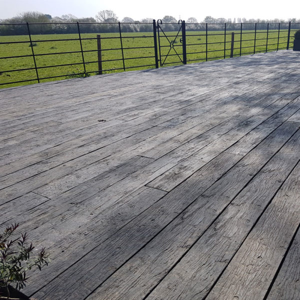 LazyLawn Millboard Decking in Weathered Oak by a field